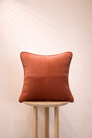 Textured Burnt Terracotta pillow on a wooden stool against a beige background